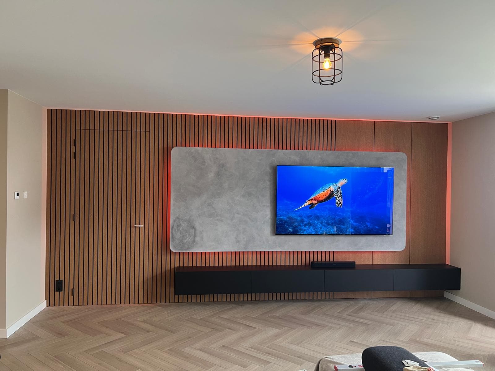 Design tv-wand met verborgen deur en zwevende elementen.